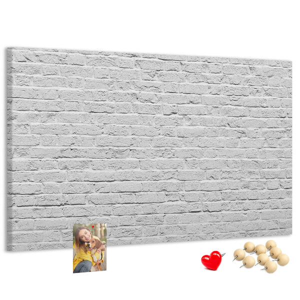 Kurk prikbord met afbeelding van witte bakstenen muur met kleurrijke punaises
