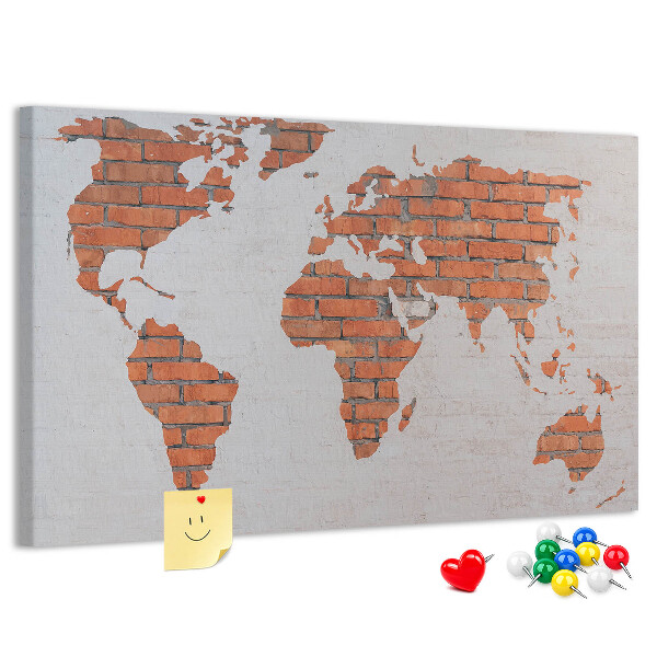 Kurkbord wereldkaart tegen een bakstenen muur