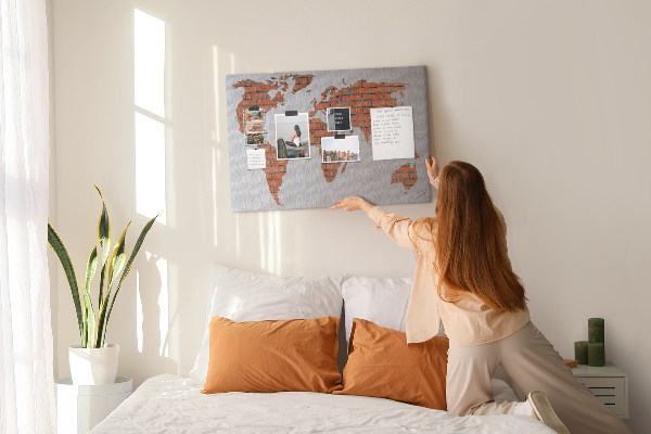 Kurkbord wereldkaart tegen een bakstenen muur