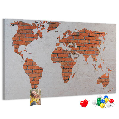 Kurkbord wereldkaart tegen een bakstenen muur