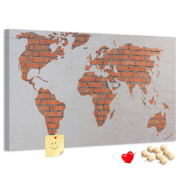 Kurkbord wereldkaart tegen een bakstenen muur