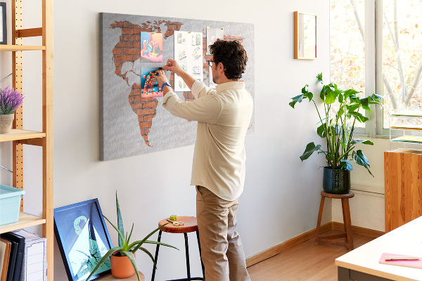 Kurkbord wereldkaart tegen een bakstenen muur