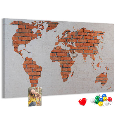 Kurkbord wereldkaart tegen een bakstenen muur