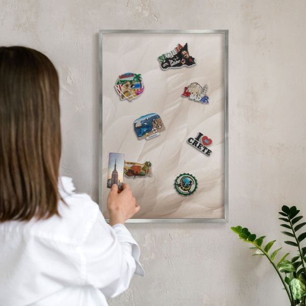Decoratief metalen magneetbord in een zilveren lijst Crèmekleurige veren
